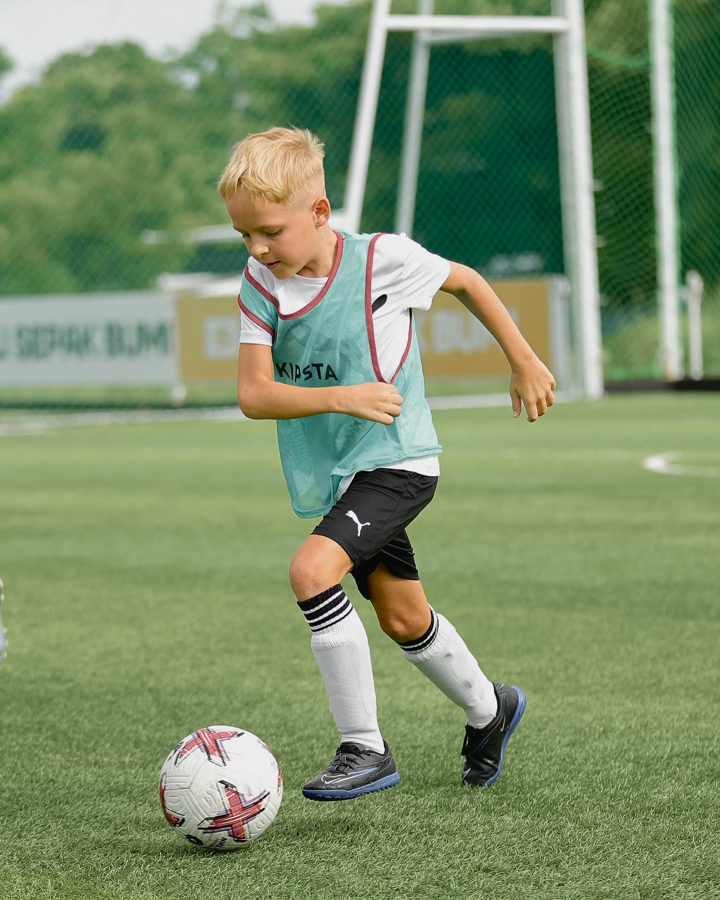 Young player dribbling the ball during a UNITY Football Bali session