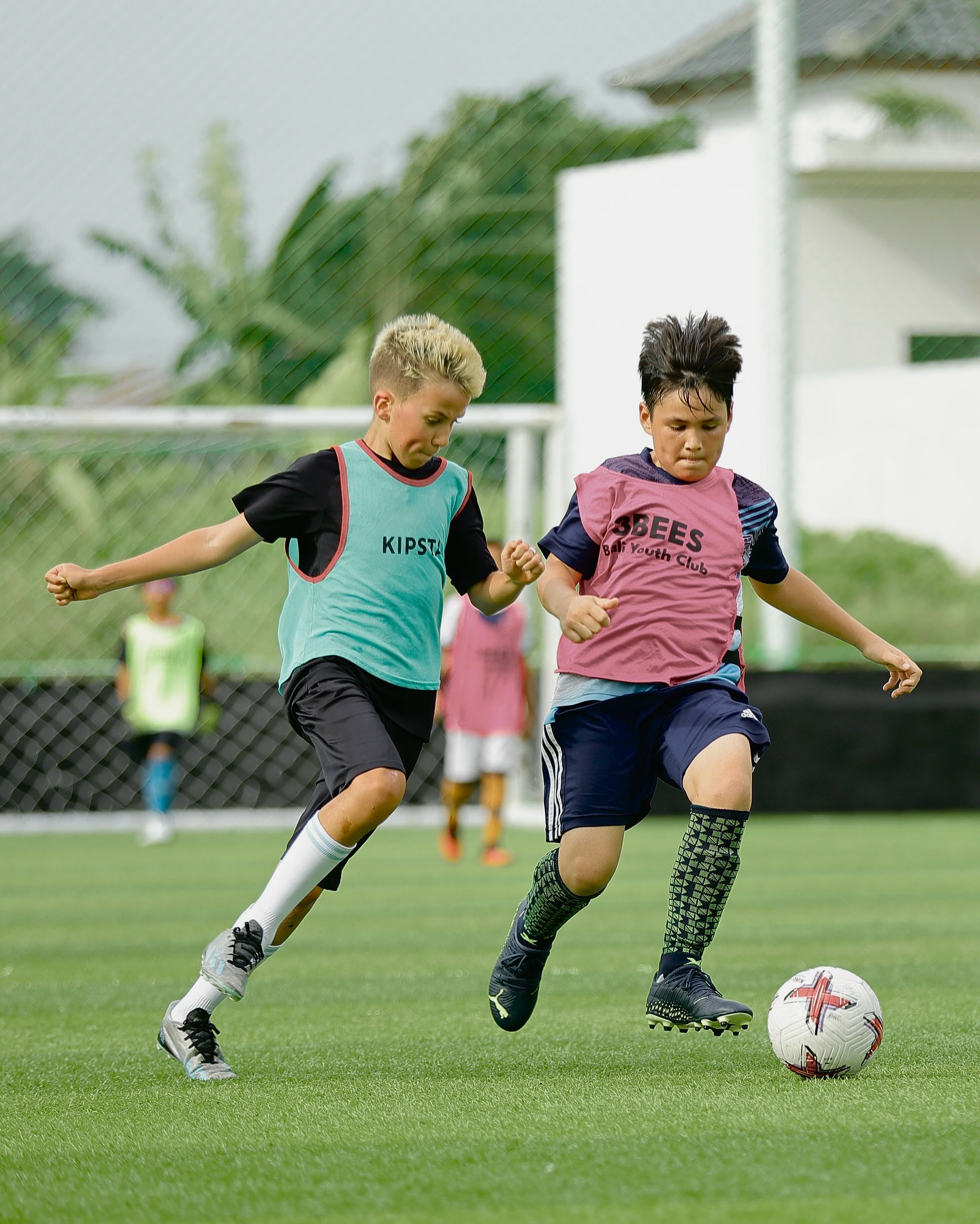 Two young UNITY Football Bali players competing for the ball during training